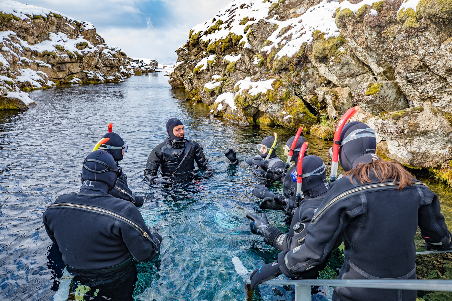 A family of snorkelers entering Silfra with their guide Stefano