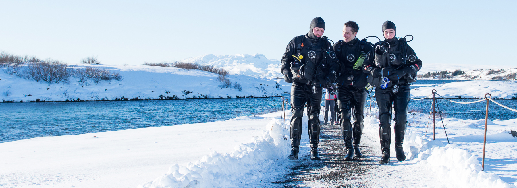 Happy divers walking back from the exit platform after their Dive in Silfra, Iceland