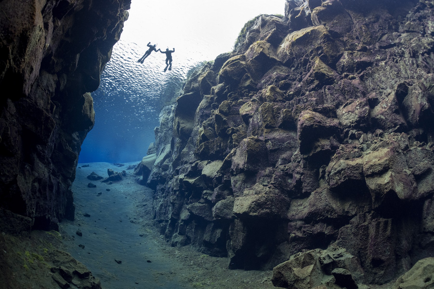 Two snorkelers from the divers perspective in Silfra Cathedral