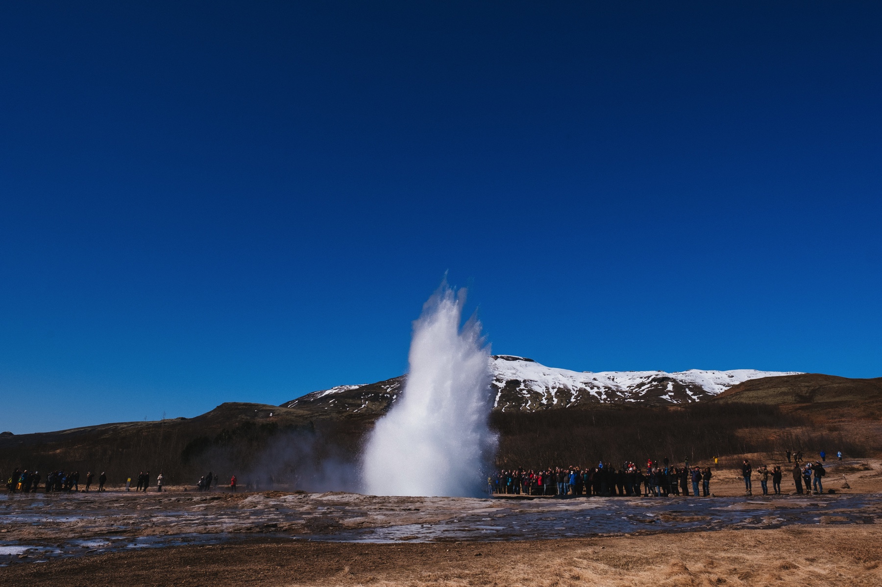 People watching as the geyser "Strokkur" erupts