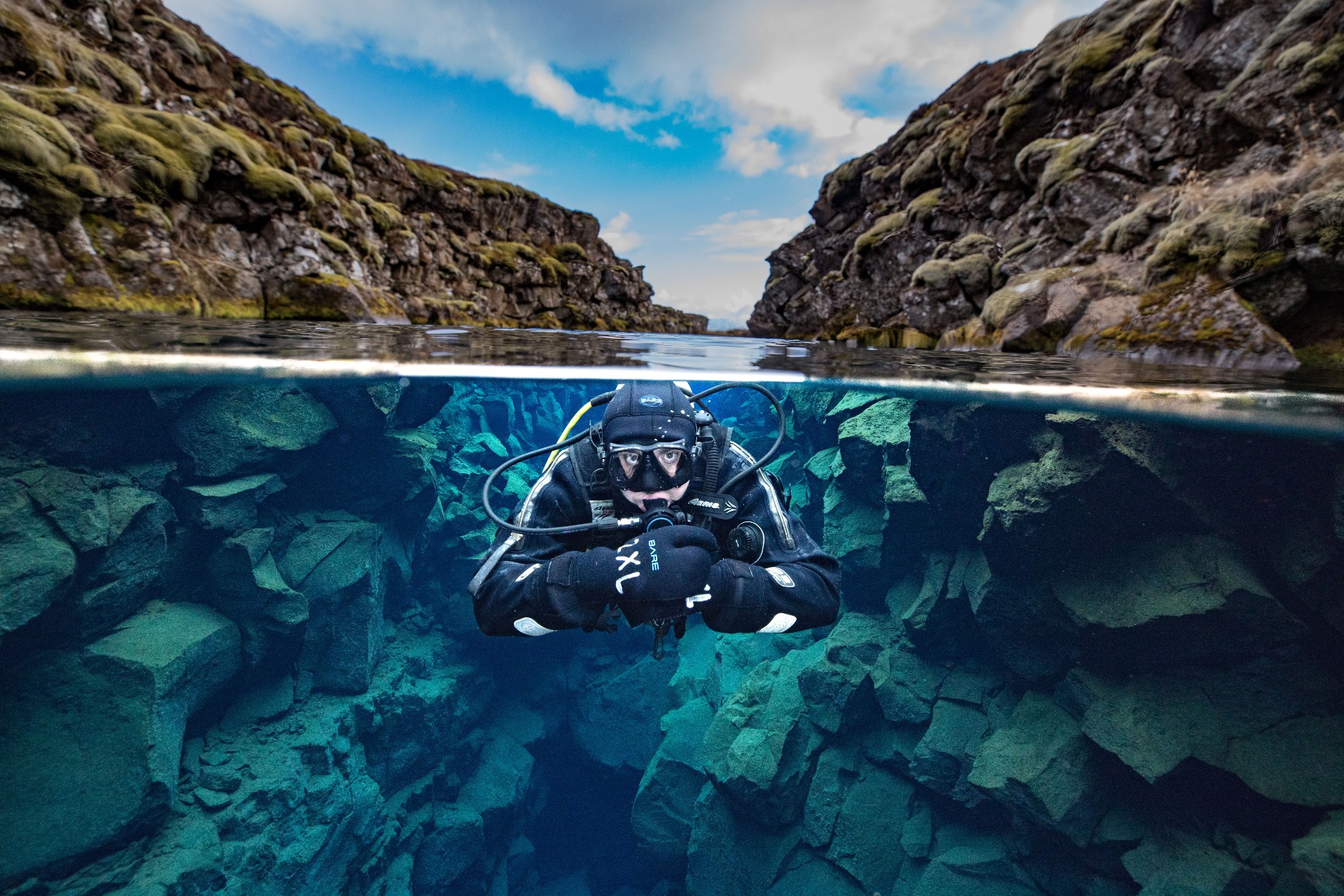 A split view photo of a diver between the continents in Silfra