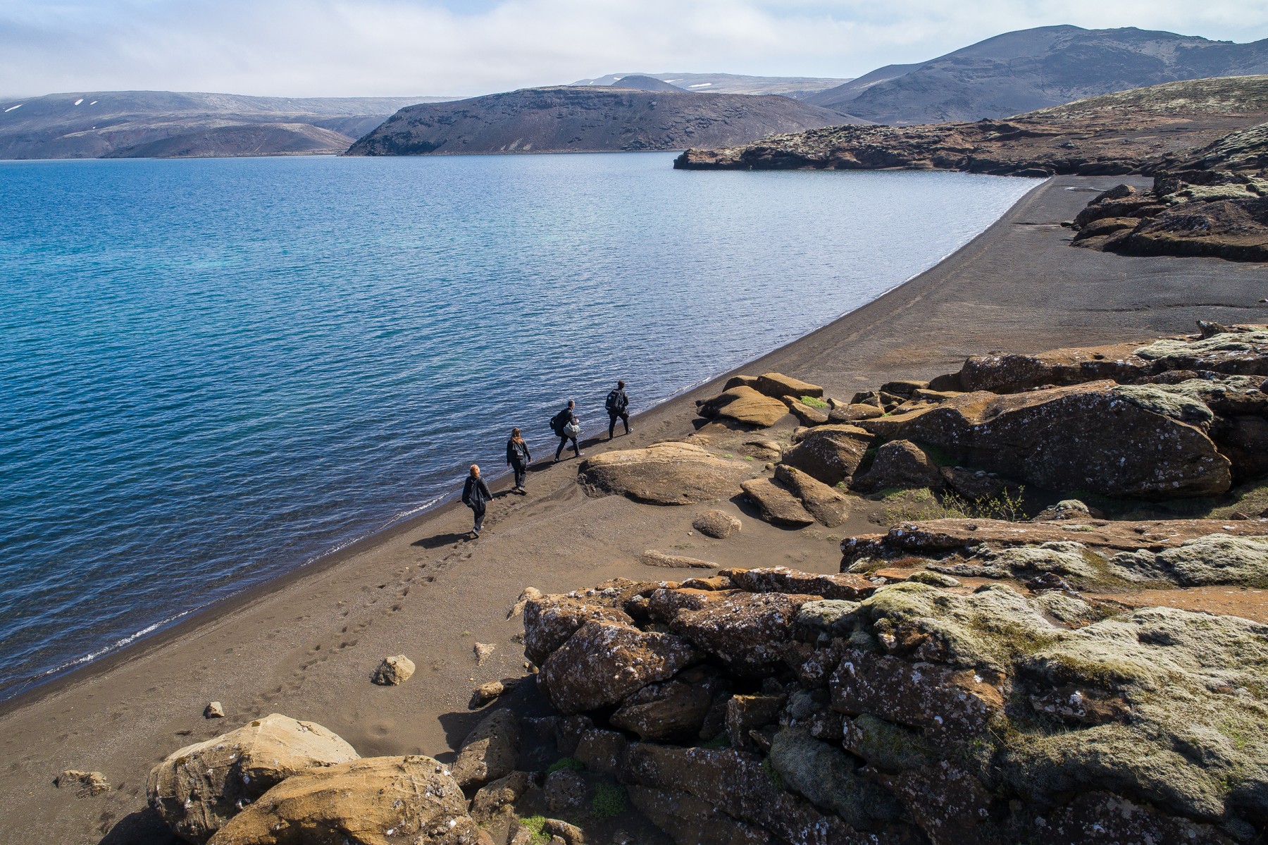 Group of snorkelers walking on the beach of Kleifarvatn