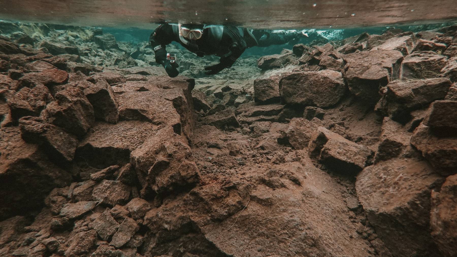 Snorkeling over rock formations in the crystal clear Silfra snorkeling-rock-formation-crystal-clear-silfra
