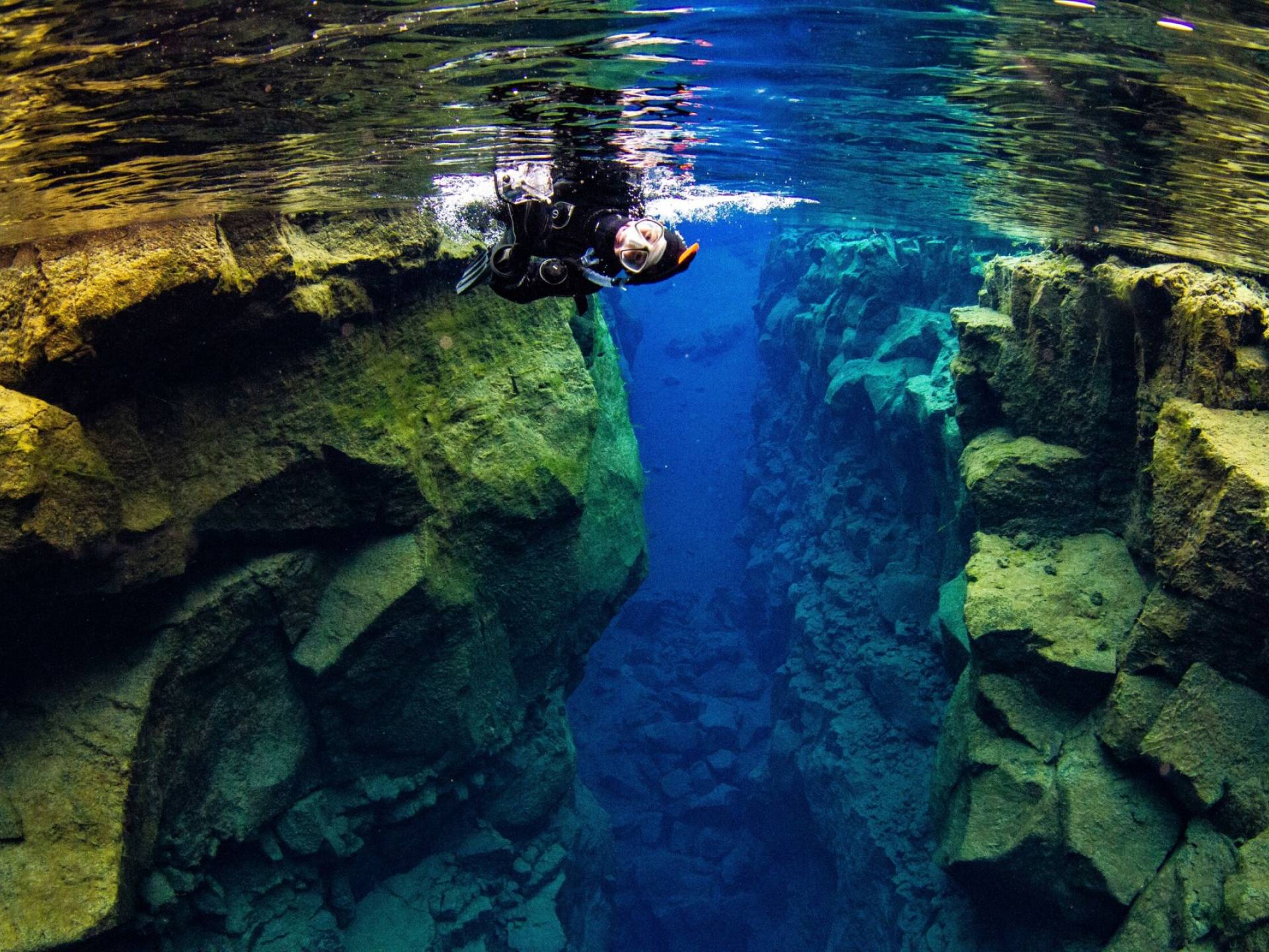 a single snorkler floating in the clear water in Silfra fissure in Þingvellir