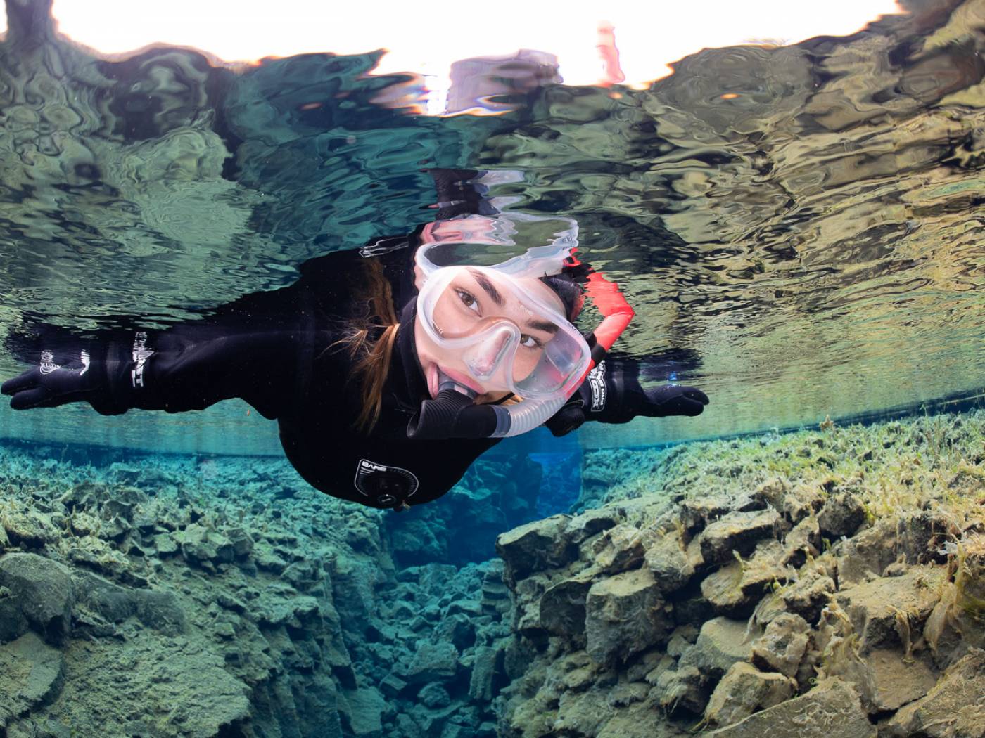 A female snorkeler in the crystal clear waters of Silfra