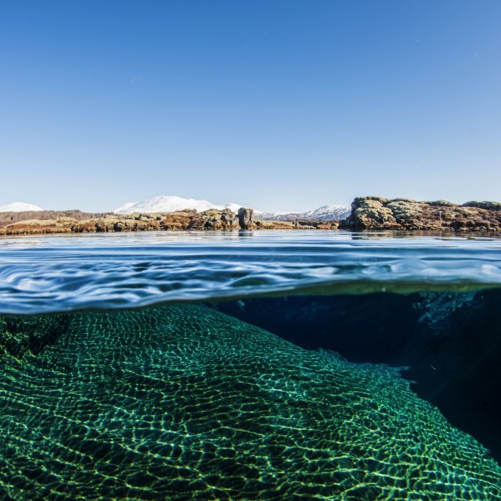 split-view-silfra-lagoon-thingvellir-iceland-snowing-mountains-720x720.jpg