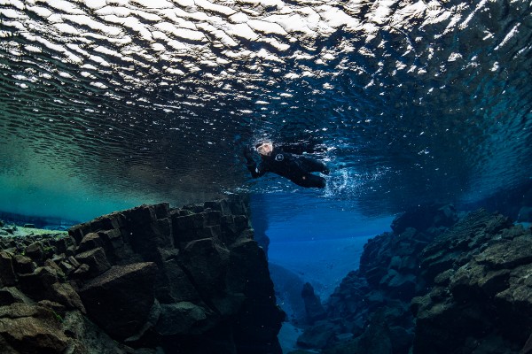 Snorkeler waving to the camera in Silfra, Iceland