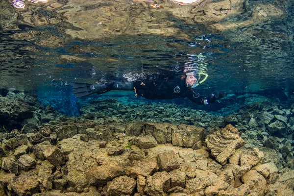 One of our guides swimming over rocks in the clearest water in the world