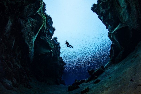 The view from below of a snorkeler between the tectonic plates in Silfra