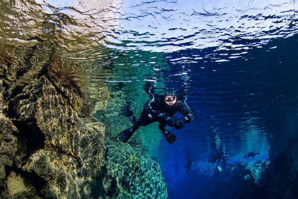Snorkelers swimming in the beautiful colors of Silfra, Iceland