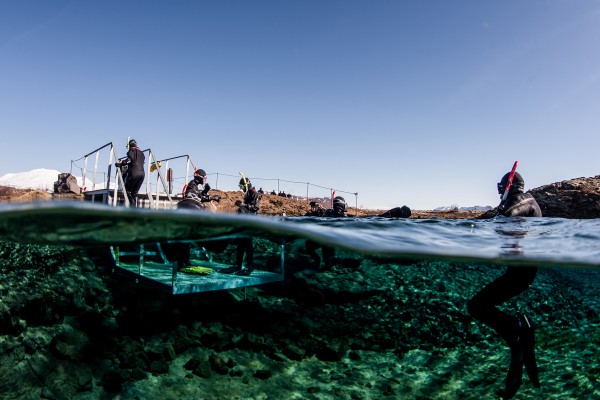 Split view image of Snorkelers at the exit platform in Silfra Lagoon