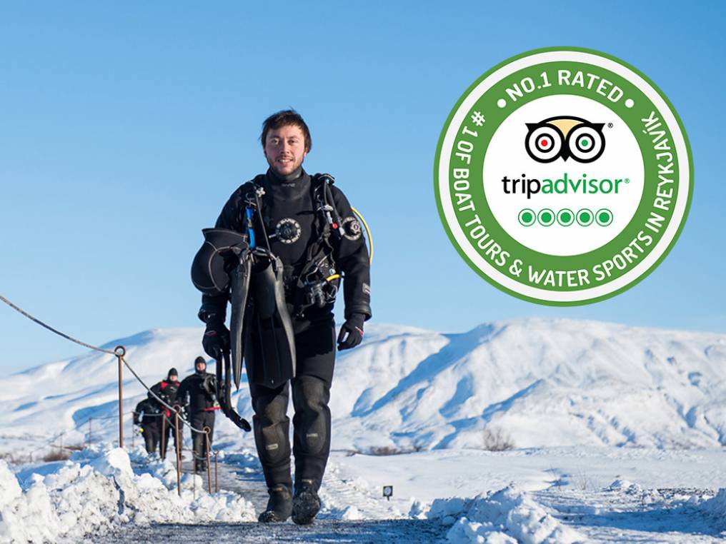Smiling DIVE.IS dive guide next to our TripAdvisor badge Smiling Dry suit diver next to our TripAdvisor badge